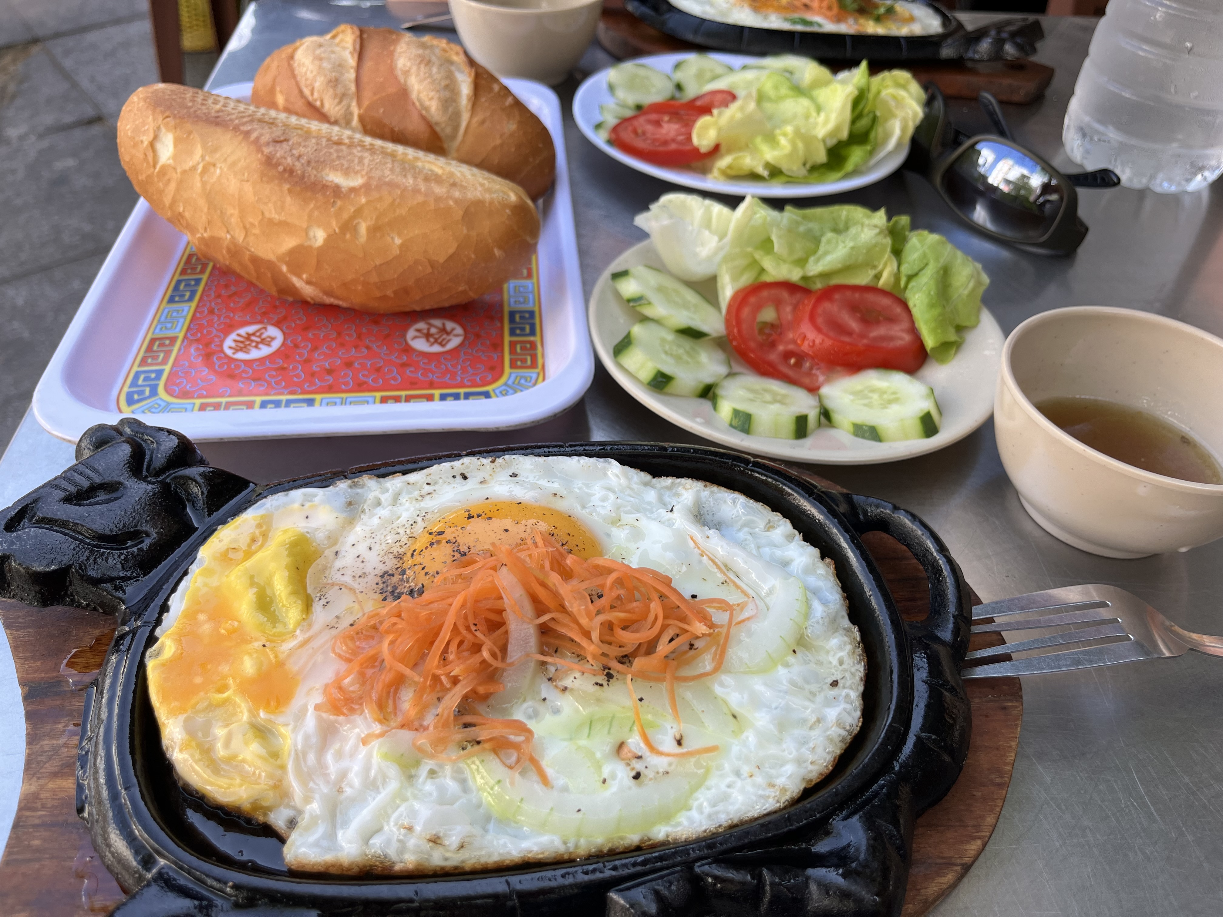 Breakfast spread: sizzling eggs, bánh mì and fresh veggies